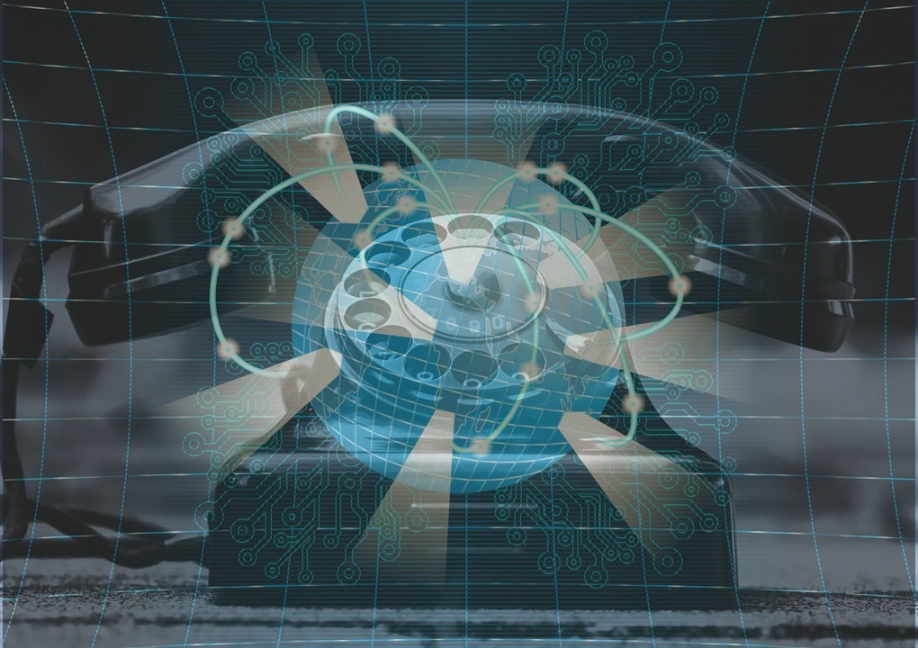 Superimposed image of a rotary dial phone and the earth's digital network.