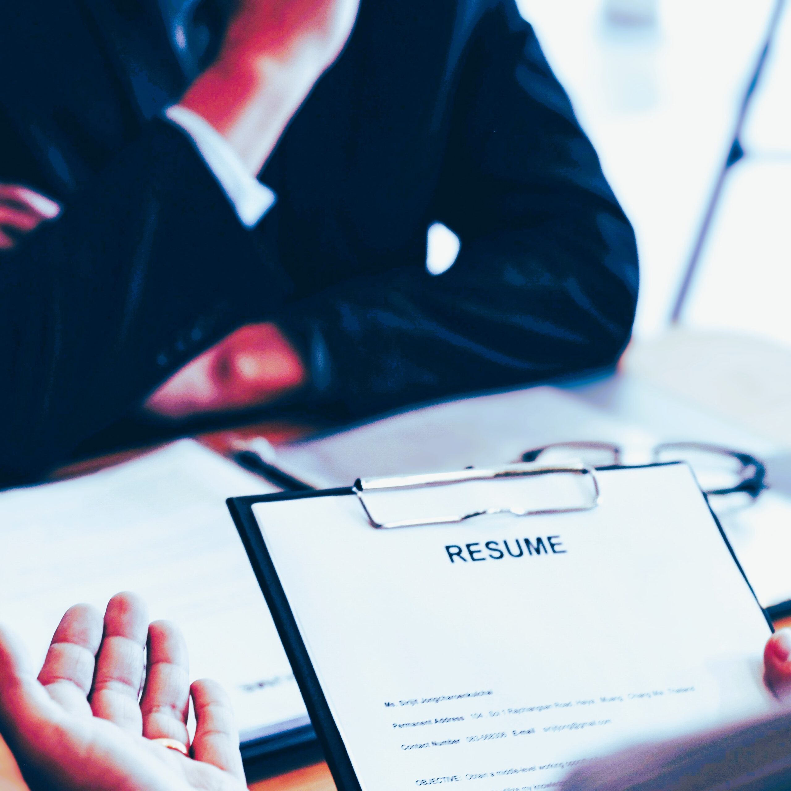 Employer holding an applicant resume during an interview.